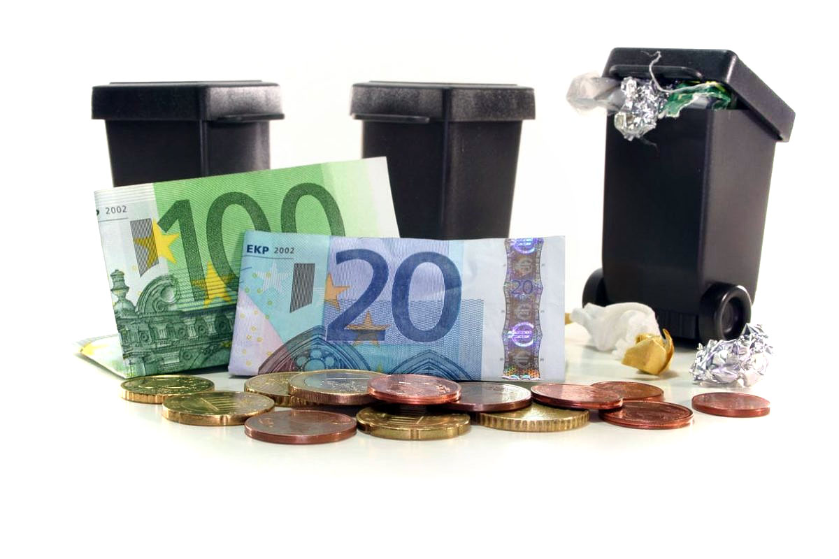 cestini dell'immondizia neri incorniciati da monete e banconote di diverso taglio