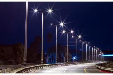 immagine di una strada di notte con a lato i lampioni accesi