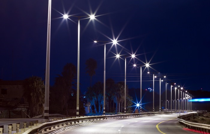 immagine di una strada di notte con a lato i lampioni accesi