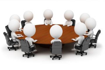 omini seduti intorno ad una tavola rotonda in riunione